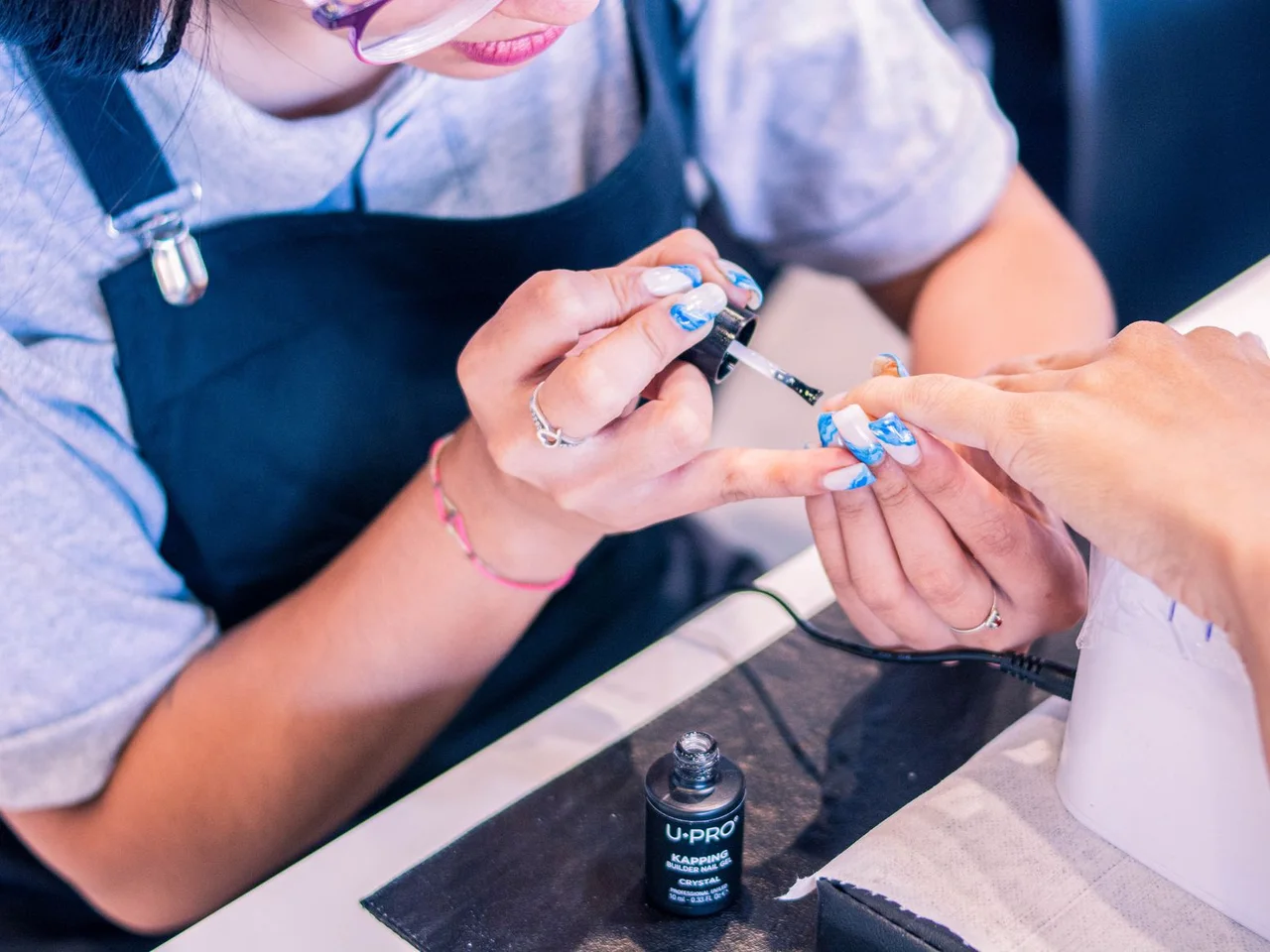 Eine Nageldesignerin bei der Maniküre